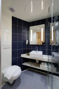 The dark blue tile in this bathroom is inviting and cozy.