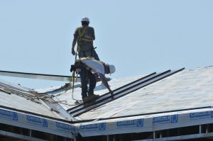 Workers install solar-reflective roofing to help with the enerrgy-efficiency of a home.